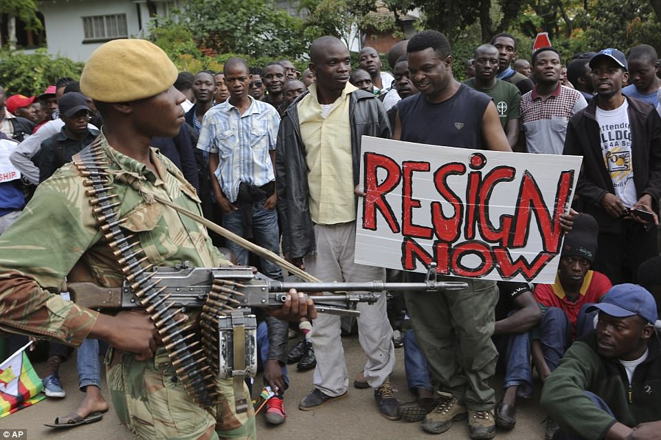 Armed soldiers control a euphoric crowd marching near State House in Harare, demanding the departure of President Robert Mugabe