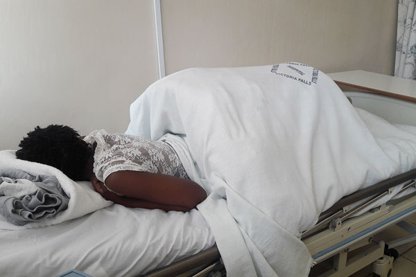 Zibusiso Moyo lies in a hospital bed in Victoria Falls;