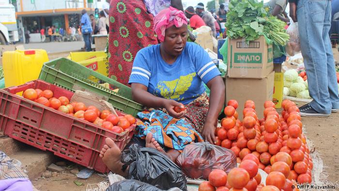 A woman selling tomatoes on a street in Harare 