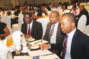 Industry and Commerce minister Mike Bimha, Confederation of Zimbabwe Industries president Sifelani Jabangwe and Reserve Bank of Zimbabwe governor John Mangudya follow proceedings at CZI Manufacturing Sector Survey Breakfast Meeting held at a local hotel in Harare yesterday.