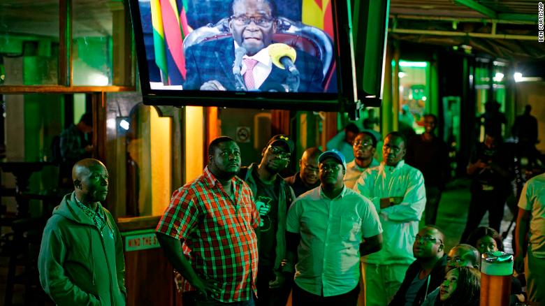 Zimbabweans watch Mugabe's televised address to the nation at a bar in downtown Harare Sunday.