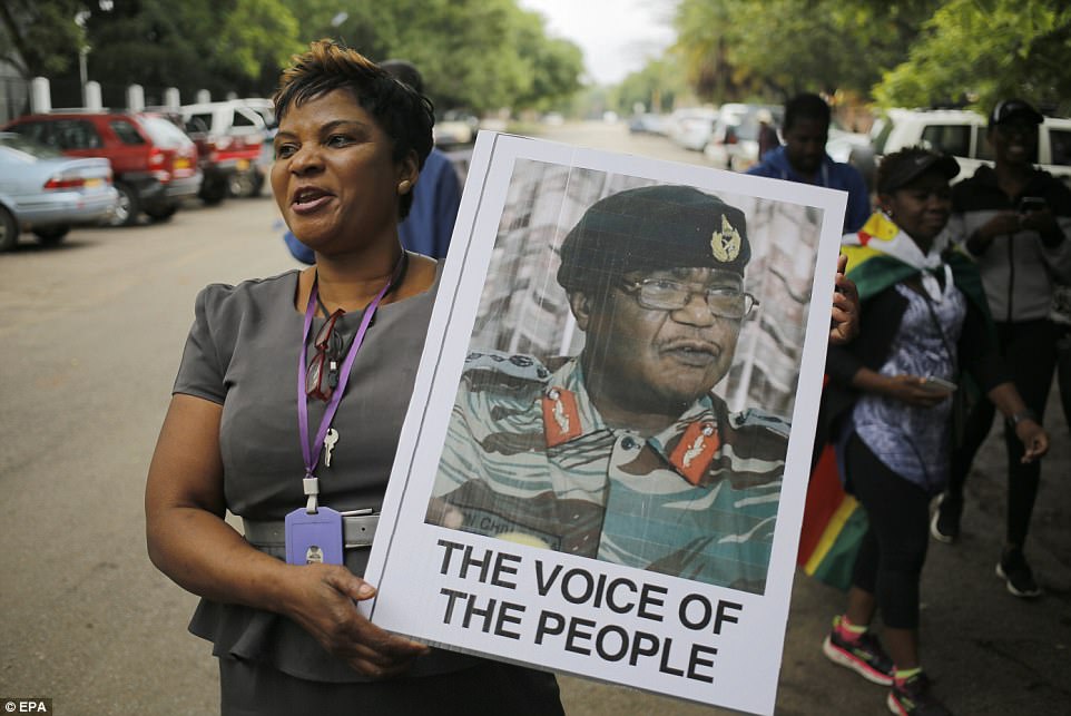 A woman holds picture of General Constantino Chiwenga, who led the coup against Robert Mugabe 