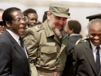 1986: Cuban President Fidel Castro (C) shares a laugh with Zimbabwean President Canaan Banana (R) and Zimbabwean Prime Minister Robert Mugabe (L) as he arrives in Harare