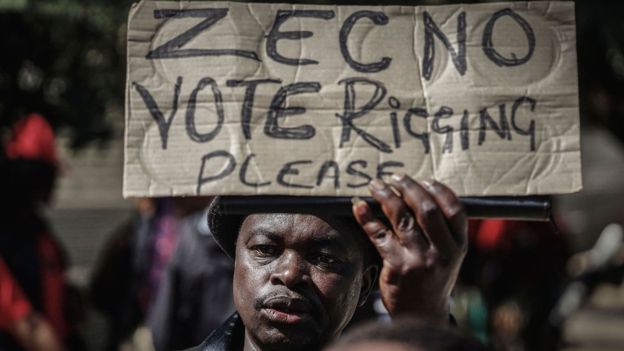 A protester waves a placard demanding transparency in Bulawayo, Zimbabwe 13 July 2018