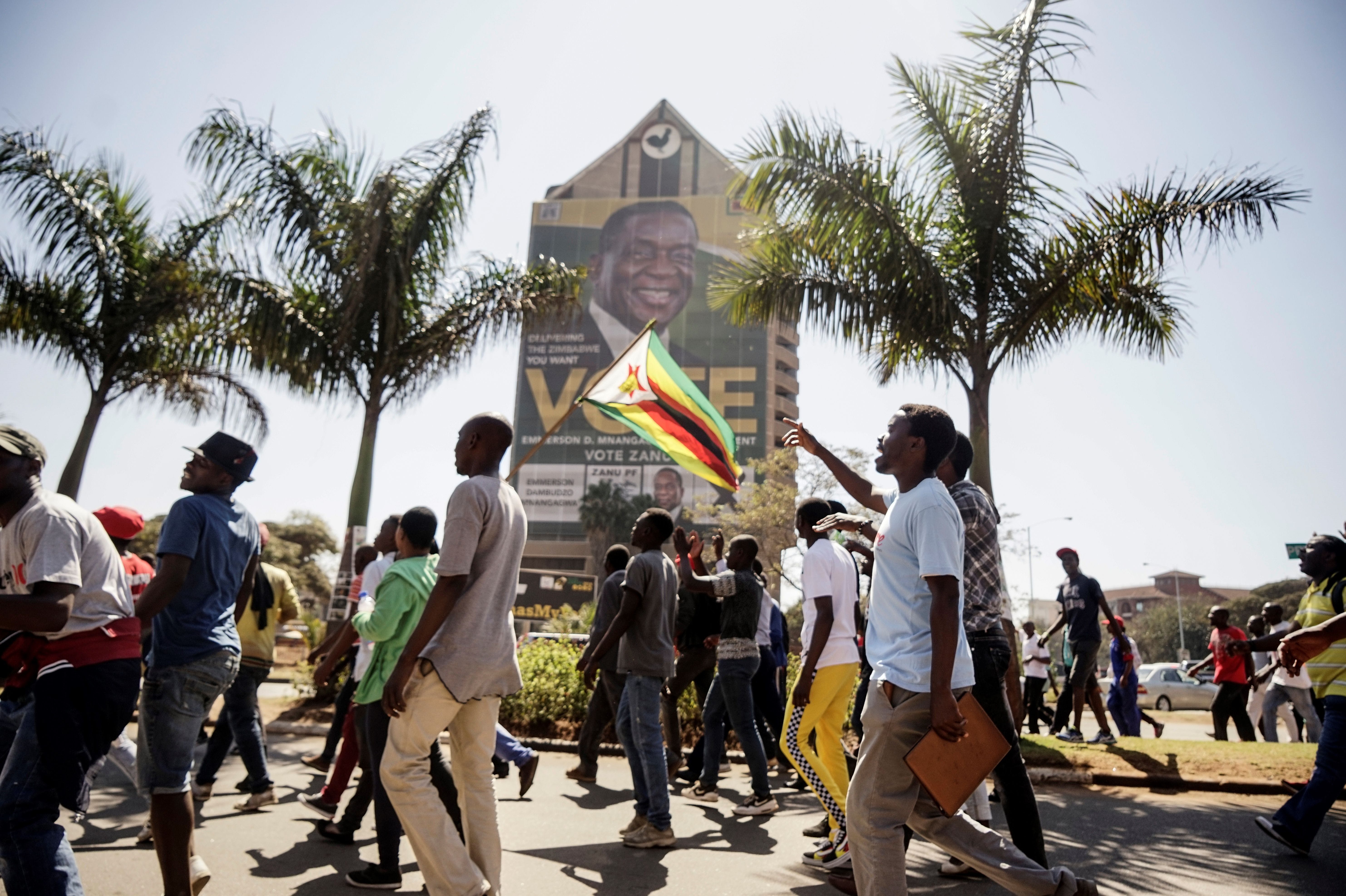 Opposition Movement for Democratic Change (MDC) supporters walk towards the Zimbabwe Electoral Commission (ZEC) headquarters on August 1, 2018 in Harare, to protest against alleged fraud in elections. - Zimbabwe's ruling ZANU-PF party won the most seats in parliament, official results showed on August 1, 2018, as the opposition MDC protested against alleged widespread fraud and the count continued in the key presidential race. (Photo by Zinyange AUNTONY / AFP) (Photo credit should read ZINYANGE AUNTONY/AFP/Getty Images)