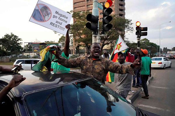 People celebrate in the streets after the resignation of Zimbabwe's president Robert Mugabe in Harare, on November 21, 2017