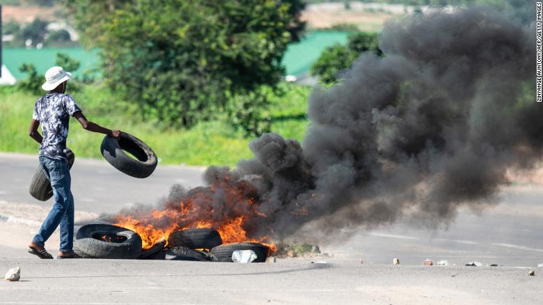 A protesters burns tyres on a road during a "stay-away" demonstration against the doubling of fuel prices on January 14, 2019 in Emakhandeni township, Bulawayo.