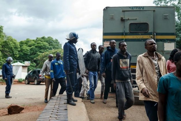 Zimbabwean anti-riot police forces watch men arrested during violent protests triggered by a sudden rise in fuel prices announced by Zimbabwean president, before their hearing at the Law Court in Harare on January 16, 2019. Picture: AFP/File/Jekesai NJIKIZANA