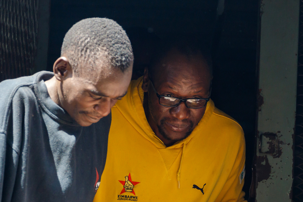 Zimbabwean cleric and activist Pastor Evan Mawarire (R) exits a prison truck as he arrives for a court hearing on subversion charges. 