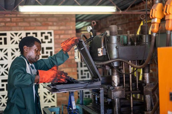 Edward, an employee of the Courteney boot company, works on a shoe sole on the production line in Zimbabwe's second city Bulawayo on January 25, 2019.