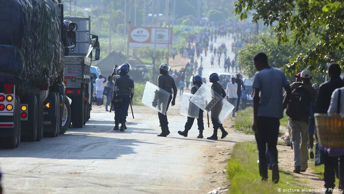 Riot police stand with shields ready Riot police stand with shields ready