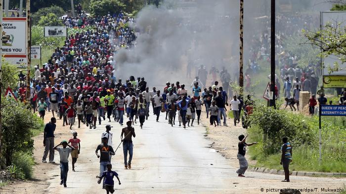 A crowd of demonstrators marching along a road (picture-alliance/dpa/T. Mukwazhi)