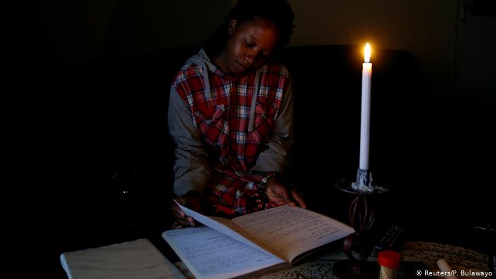 A women reads a book by candlelight A women reads a book by candlelight