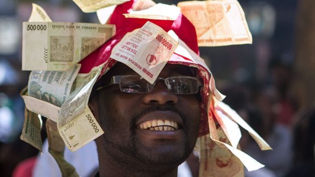 A man wearing a hat decorated with worthless notes, Harare, Zimbabwe - 2016