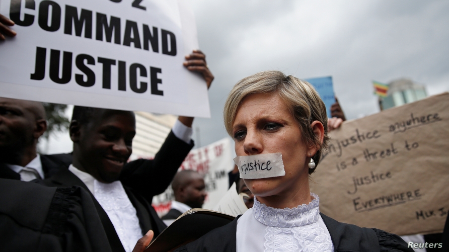 Zimbabwean lawyers carry placards as they march to demand justice for people detained in jail and others facing fast-track trials following recent protests in Harare, Zimbabwe, January 29, 2019. 
