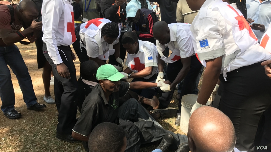 Zimbabwe Red Cross Society officials treat members of the opposition who were injured after clashes with the police in Harare, Aug. 16, 2019. (Columbus Mavhunga/VOA)