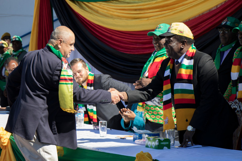 Zimbabwean President Emmerson Mnangagwa shakes hands after addressing a meeting attended by white Zimbabwean farmers and businessmen on July 21, 2018 in Harare.