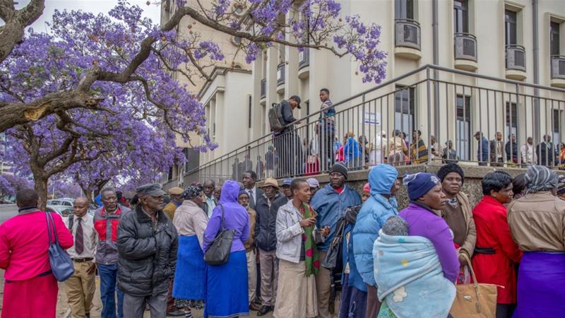 People queue to withdraw their pensions outside a branch of the Central Africa Building Society in Harare, Zimbabwe [File: Cynthia R Matonhodze/Bloomberg]