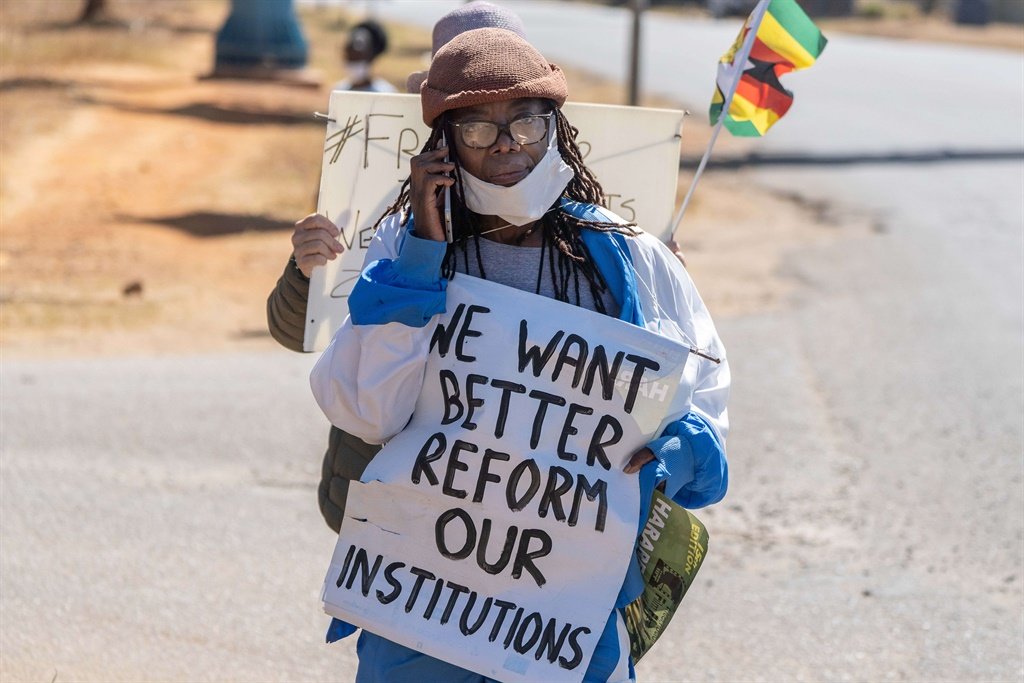 Zimbabwean novelist Tsitsi Dangarembga holds a placard during an anti-corruption protest march along Borrowdale road, on July 31, 2020 in Harare.