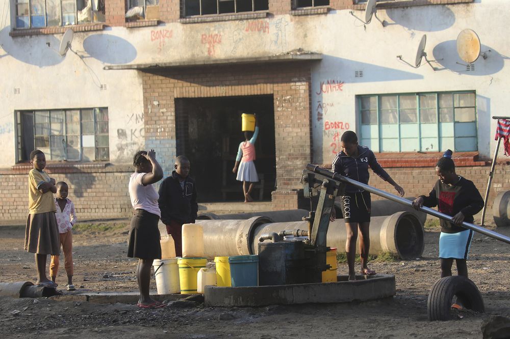 Children fetch water from a borehole in a poor neighborhood in Harare, Aug, 24.