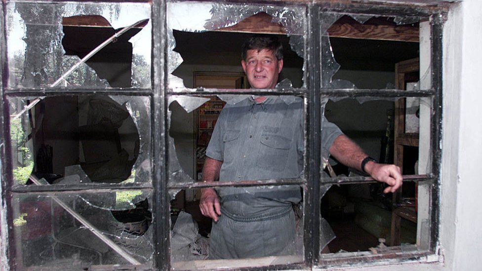 Paul Retzlaff in front of a broken window at his home in Arcturus, 30km east of Zimbabwe's capital, Harare, a day after clashes broke out at his farm - 12 April 2000