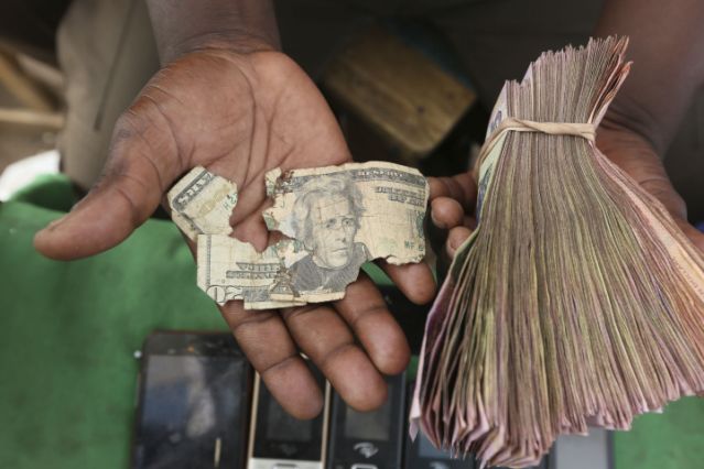 Zimbabwe Mending Dollars Currency dealers in Zimbabwe are repairing old US dollar notes