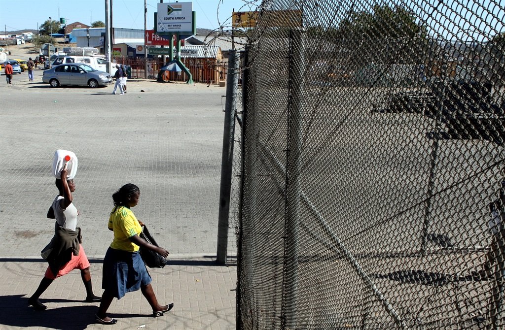 MUSINA, SOUTH AFRICA ? JULY 06: Two women cross th