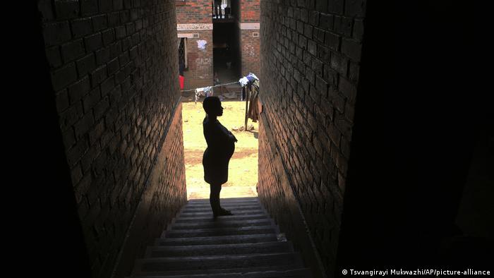 A pregnant woman waits in a passageway for her turn to deliver her baby, in Harare, Zimbabwe