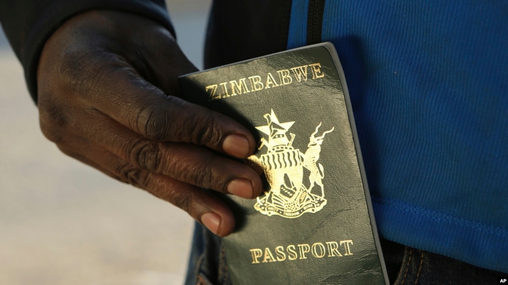 FILE - A man puts an expired passport in his pocket while waiting in a queue to submit an application for a new passport at the main office in Harare, June 14, 2019. 