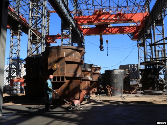 FILE - A person works at Tsingshan's Dinson Iron and Steel Company production plant in Manhize village in Mvuma, Zimbabwe, June 20, 2024