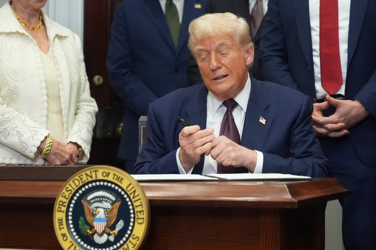 President Donald Trump signs an executive order restarting the Presidential Fitness Test in public schools, Thursday, July 31, 2025, in the Roosevelt Room of the White House in Washington. (AP Photo/Jacquelyn Martin)