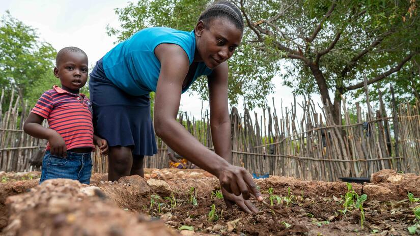 A mother and child in Binga, Zimbabwe tend to a garden using drought resistant planting techniques.